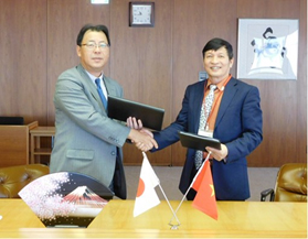 JFE Steel Senior Vice President Shichinobu Nasu (left) and AGRIMECO President and CEO Le Van An
shake hands after signing the joint venture agreement on December 2, 2016
